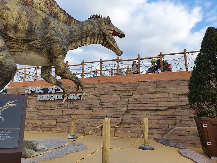 Kids looking at a roaring dinosaur at eye level from a platform
