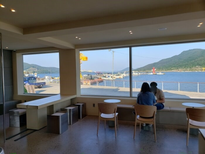Seating such as cube stools and chairs along the window with a view of the water