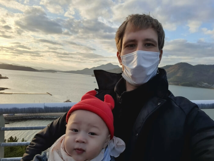 Nate and Noah on a cliff at sunset overlooking the water and mountains at the Goseong Dinosaur World Expo