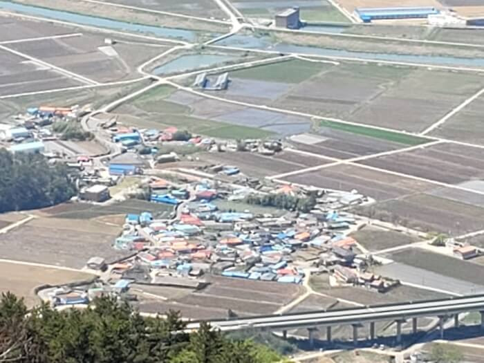 A view of our village from the peak, with rice fields and a highway bridge around the village