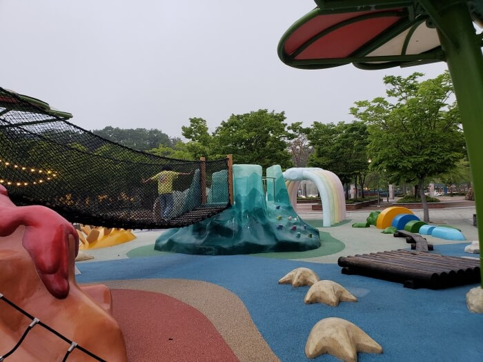 A playground with a dinosaur tracks and a rope bridge at the Goseong Dinosaur Theme Park