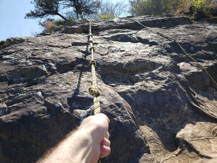 Nate holding the rope to climb up the rocky slope at Geobug Rock