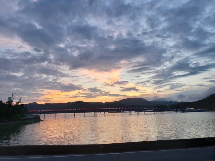View of Haejigae Bridge from Sunset Café during a sunset over the mountains and water