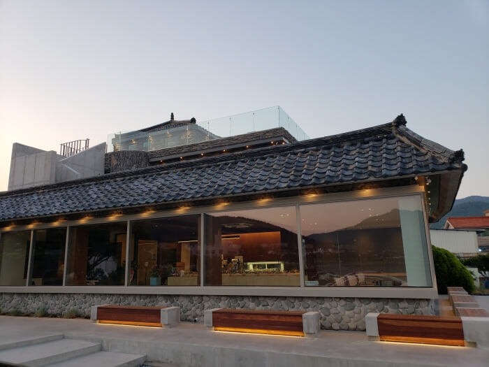 Traditional style roof of the café with benches illuminated in the evening