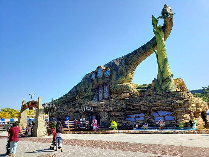 A long-necked dinosaur above the Dinosaur Character Park building