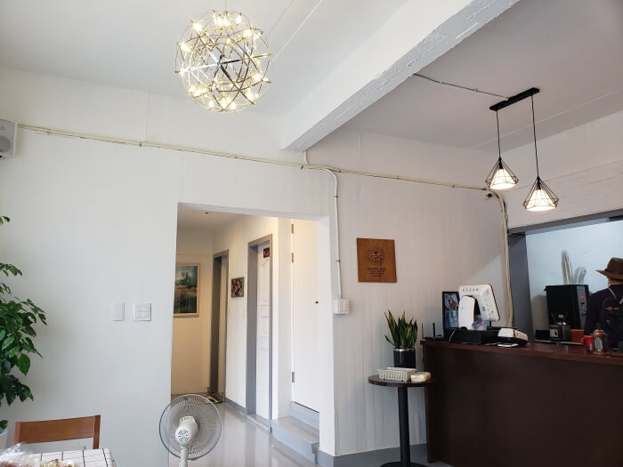A modern light fixture hanging near the ordering station and the hallway where the restrooms are