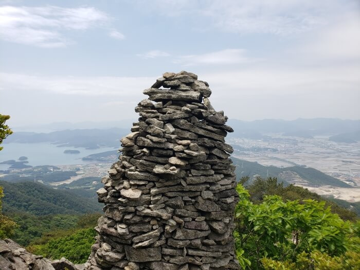 A closeup of a rock structure near Byeogbangsan against a nice view of the sea and islands