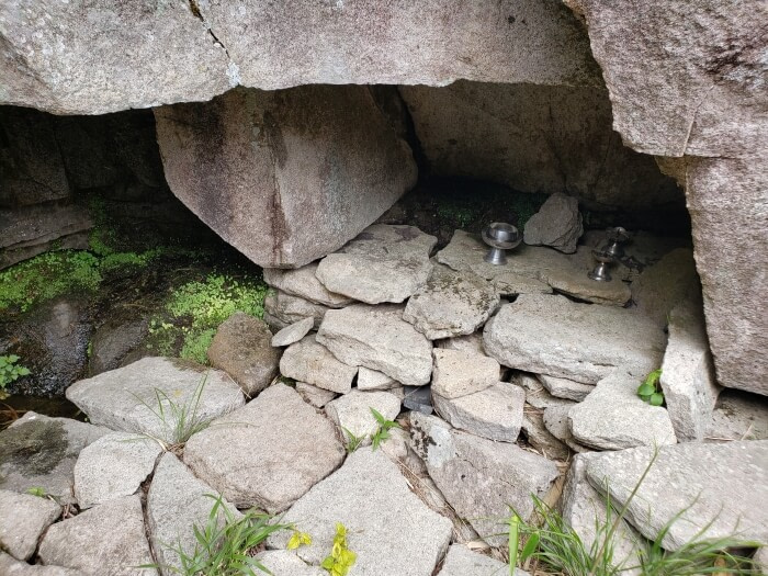 A few utensils in a small opening under the rocky cliff