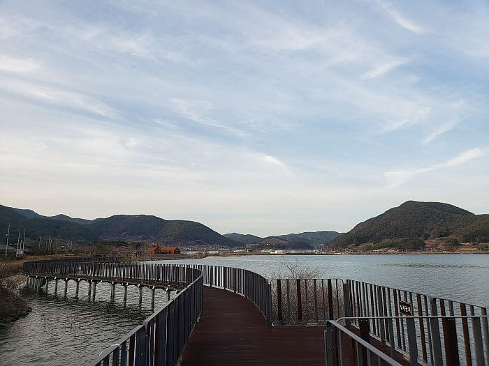 The boardwalk along the water surrounded by mountains