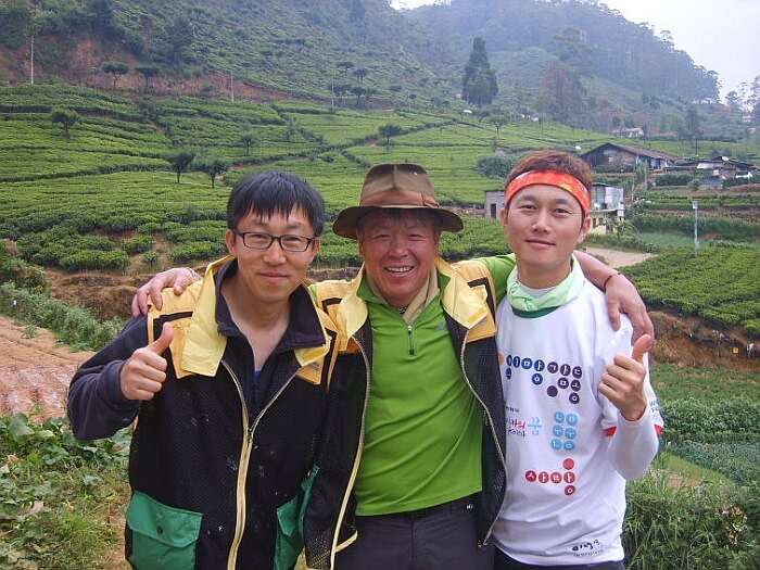 Eom Hong Gil standing in front of the green countryside