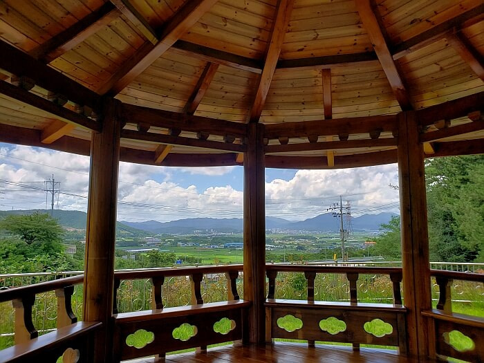A gazebo facing a town with mountains in the background