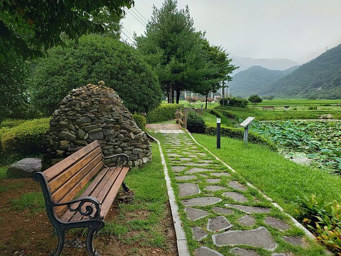 A bench and stone pagoda along a stone path