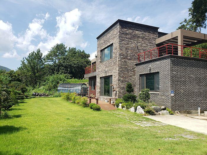 A brick building with a grassy front yard