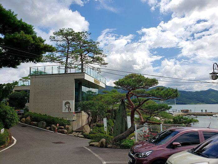 Trees growing outside and sticking up through the roof of Dessert 39 Café in front of the sea