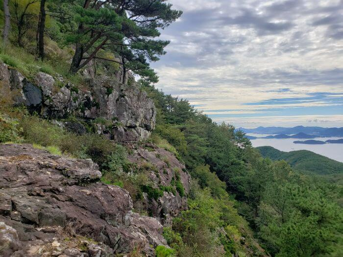 Rocks on the side of a mountain with a view of islands