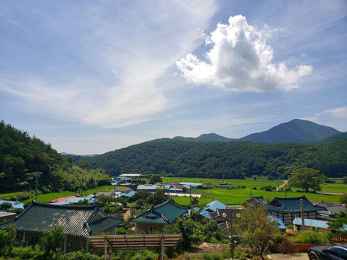 View of village below with rice fields and mountains