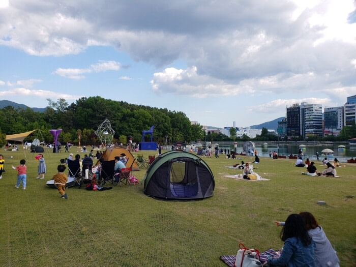 Koreans talking on the grass in tents and on blankets