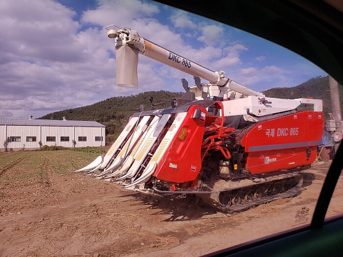 A rice harvesting machine with an extension on the top