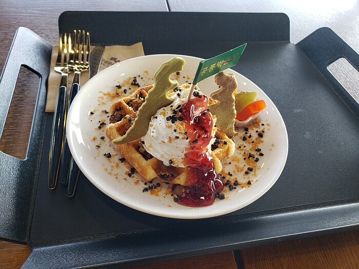 Waffle with dinosaur cookies, jam, and cream