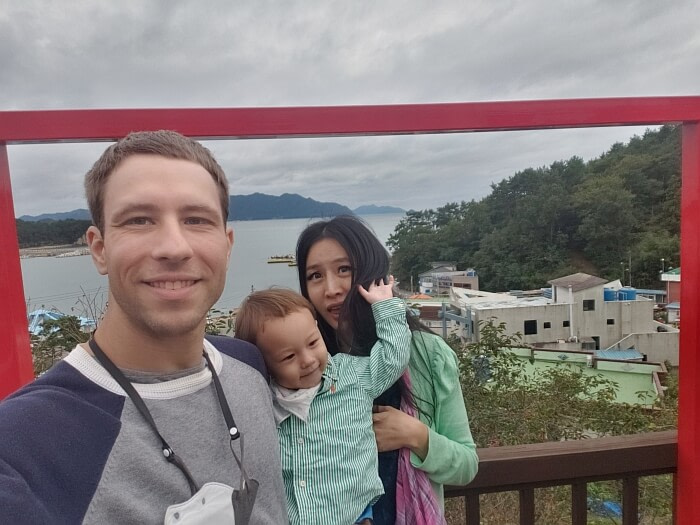 Funny family photo of baby Noah reaching behind to grab his mother's hair