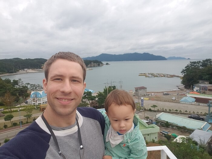 Nate and Noah in front of the sea and a village below