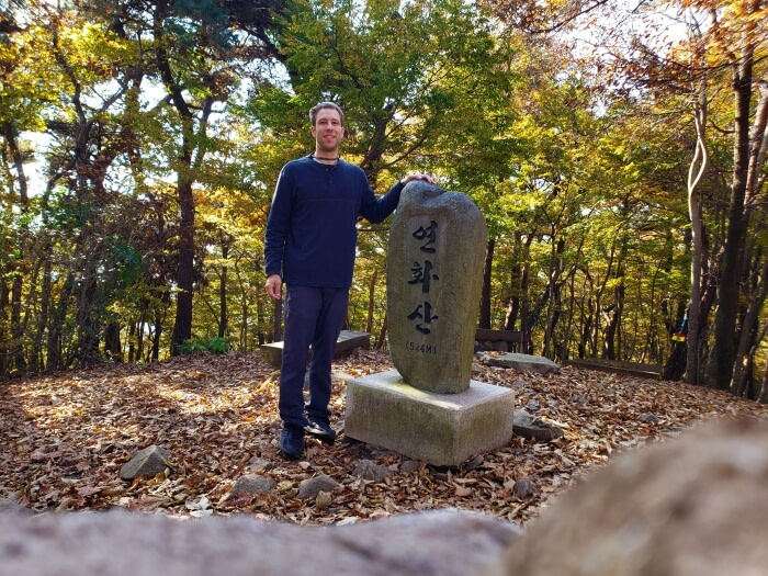 Goseong Guy standing with headstone at Yeonhwasan Peak