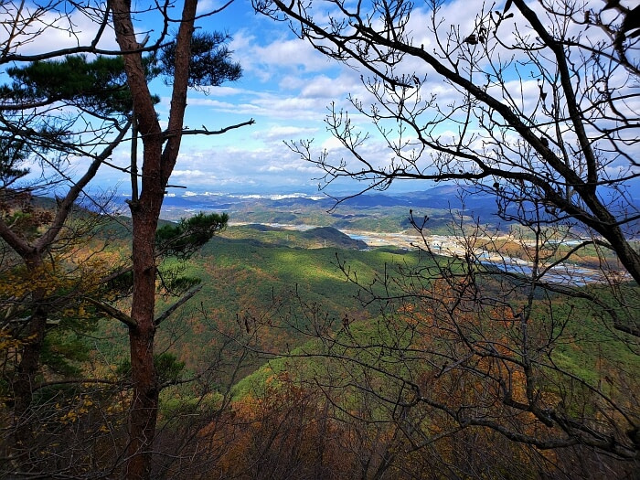 The view from Yeonhwasan Peak 1 of green mountain slopes and towns in the distance