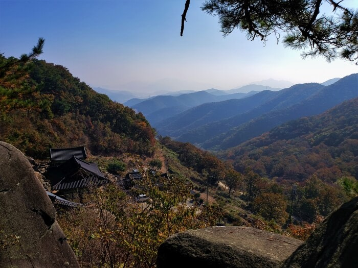 A series of mountain peaks in the distance with the "enemy palace" temple below
