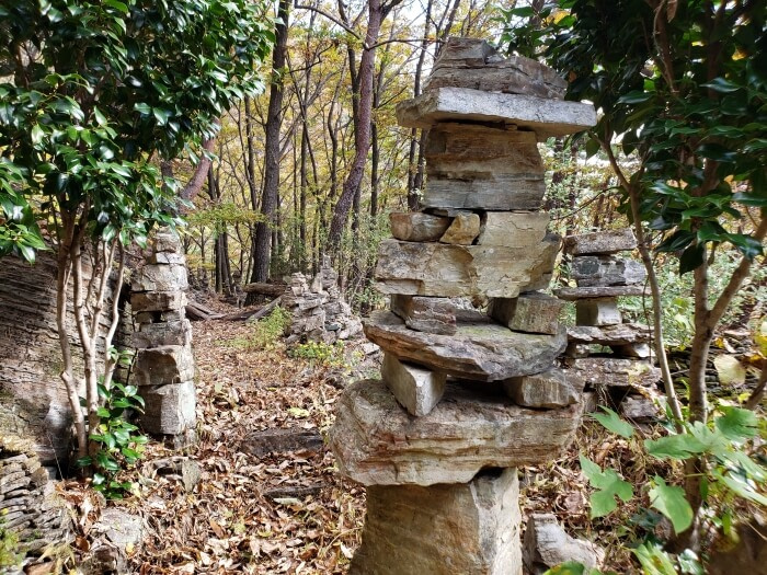 Rocks stacked near the entrance of a cave house in a forest
