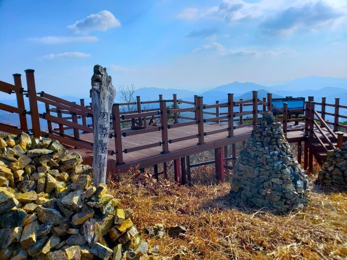 A carved wooden stick in rock piles next to a lookout deck