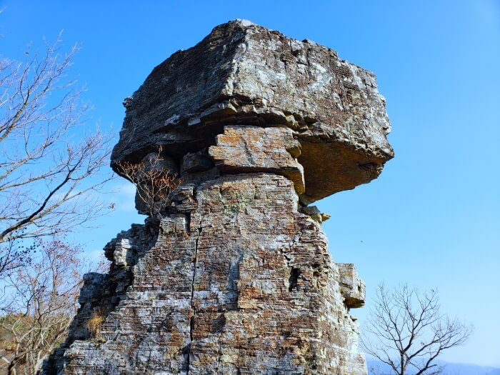 A large rock sticking into the sky with a square top