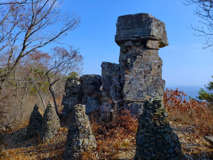 A large rock surrounded by stacked stone pagodas