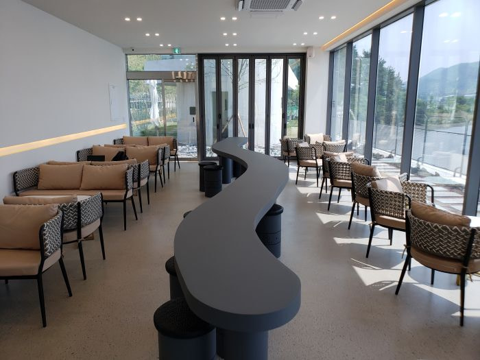 A long, curved, black table in a The Hideout Café