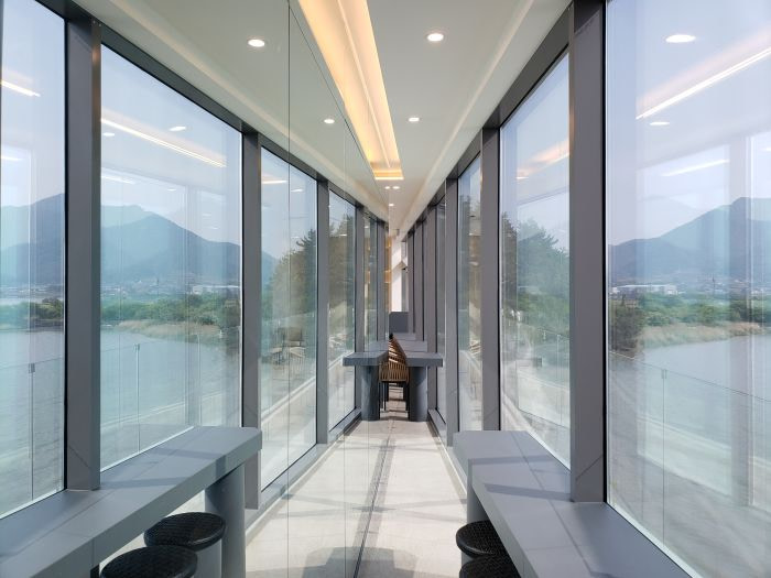A mirror on a wall reflecting the view of the sea and mountains