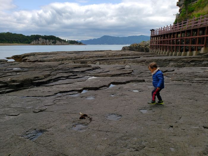 Baby Noah stepping into dinosaur footprints at Sangjogam Park in Goseong, Gyeongnam, Korea