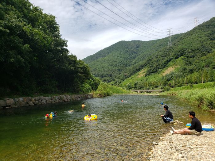 Kids swimming in a clean river in the valley surrounded by mountains
