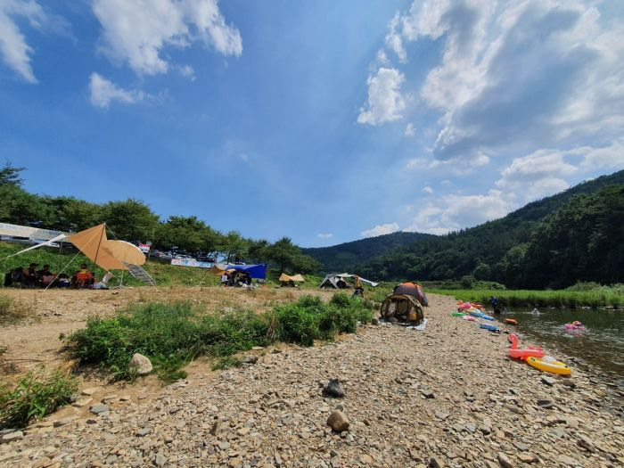Tents and equipment on the shore of a river