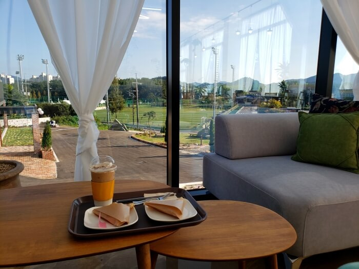 A tray of crepes and coffee with a view of the Goseong Sports Park