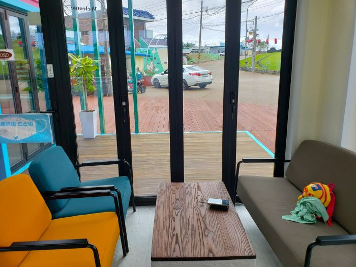 Village houses visible from a café with couches along the window