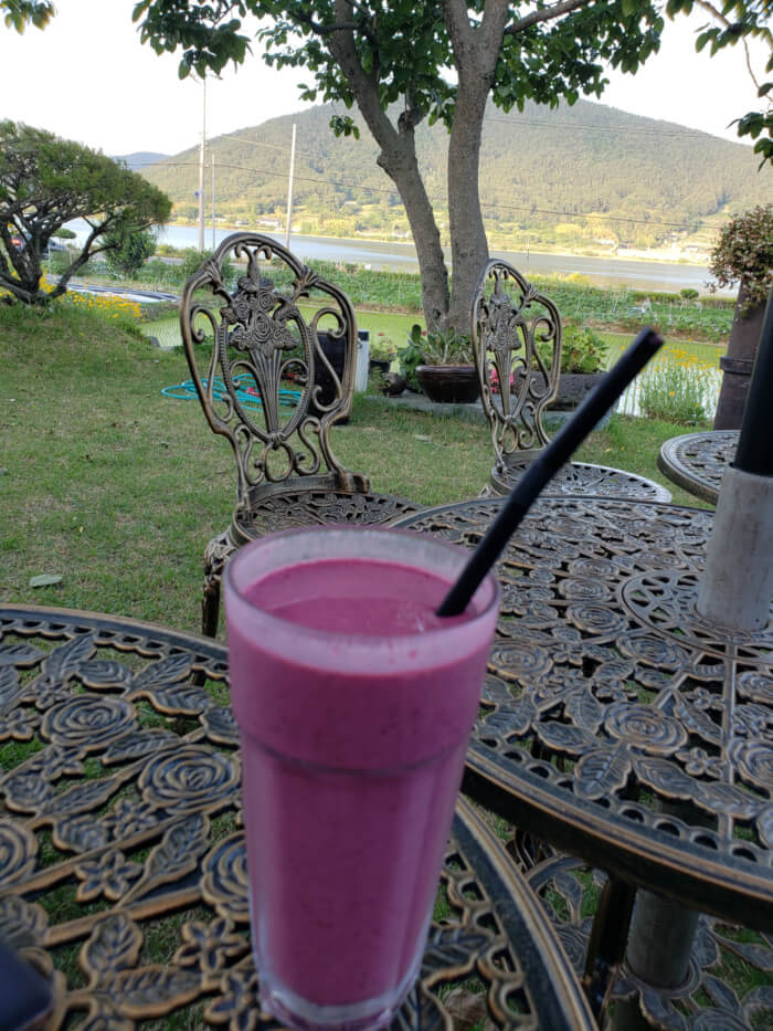 Aronia juice on a small metal table outside on the grass