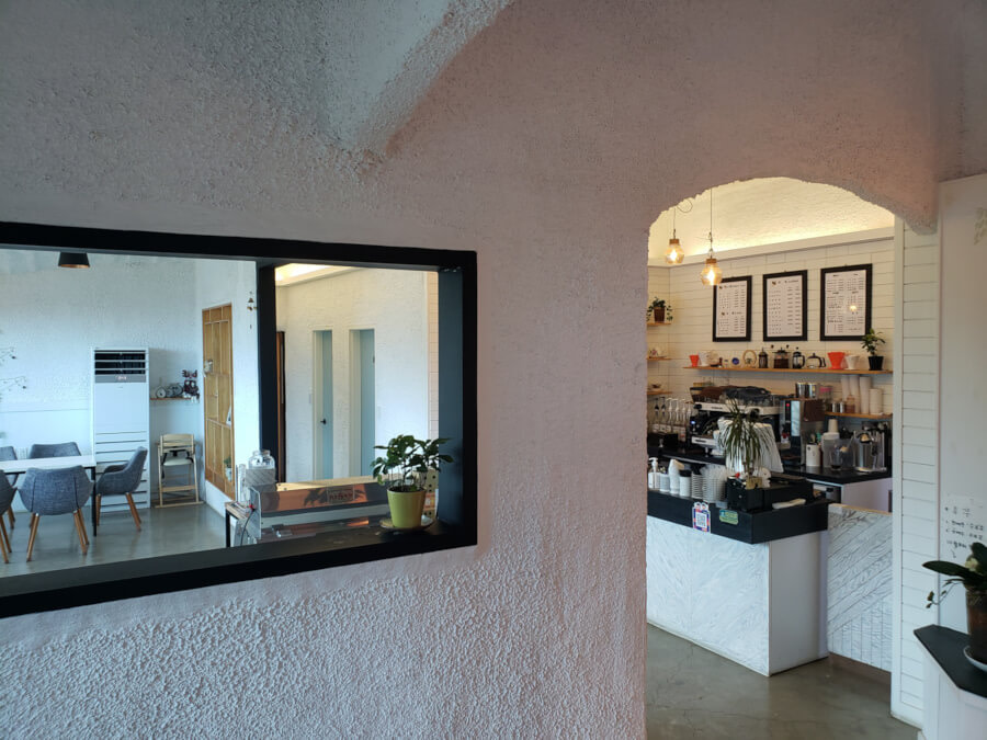 Interior entrance of the café with white walls and cashier ahead