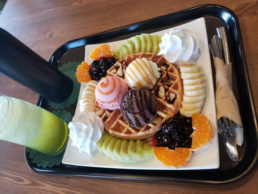 Waffle with ice cream, fruit, and whipped cream
