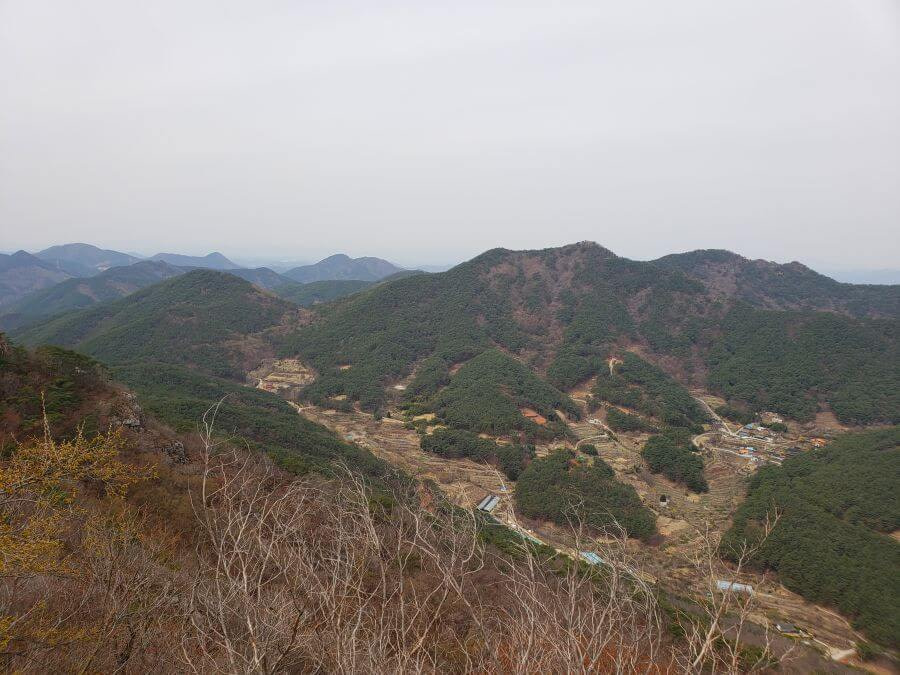 A countryside view of other mountains from a mountaintop