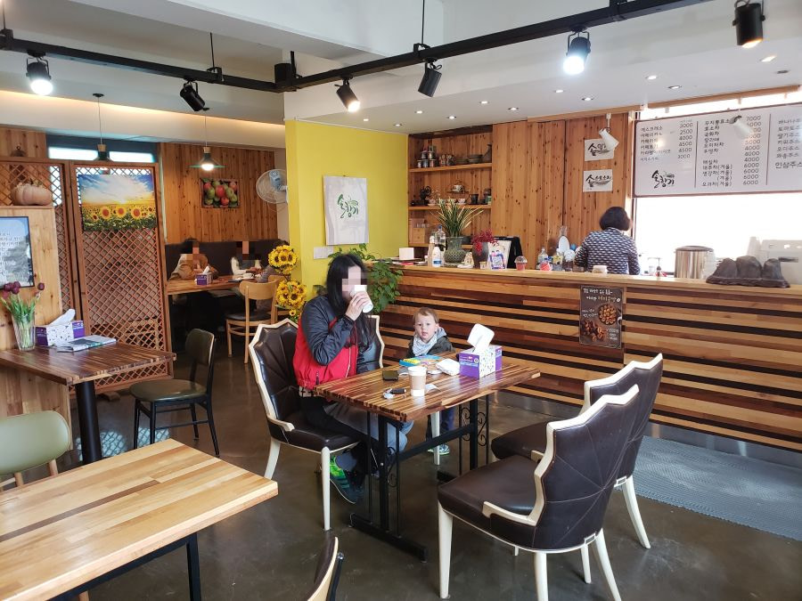 Alice and baby Noah sitting at a table in Sol Hyangi Café
