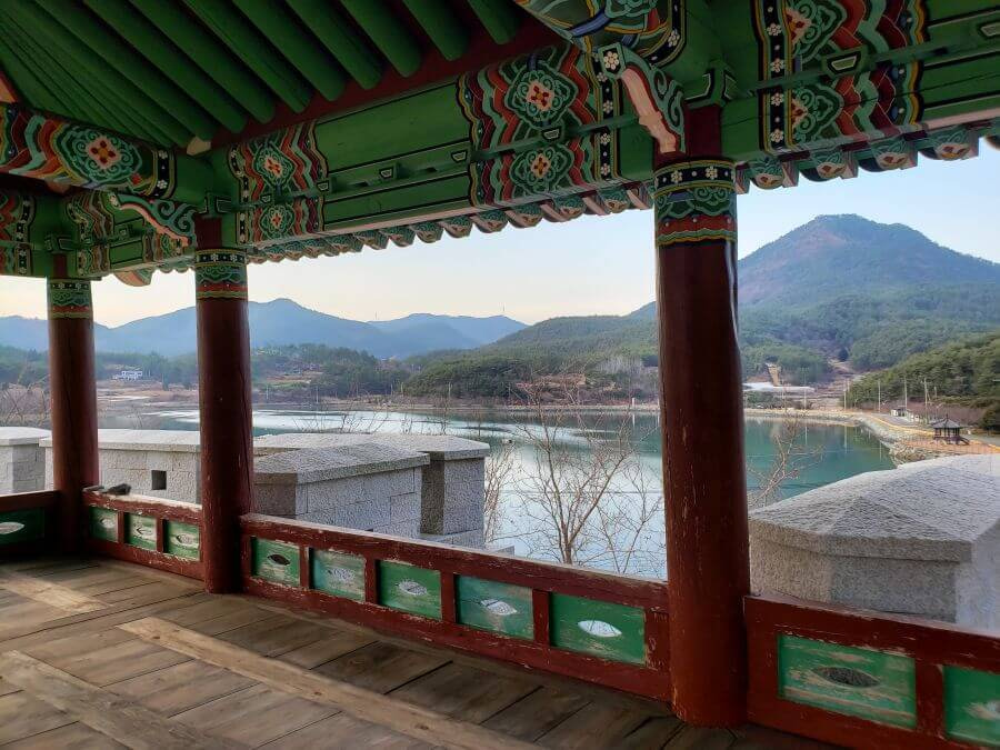 Atop a wooden, painted fortress gate viewing the sea and mountains