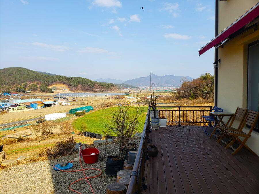 The deck of Café Ludia overlooking a village and its fields