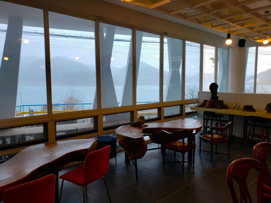 Carved wooden tables along windows with sea view