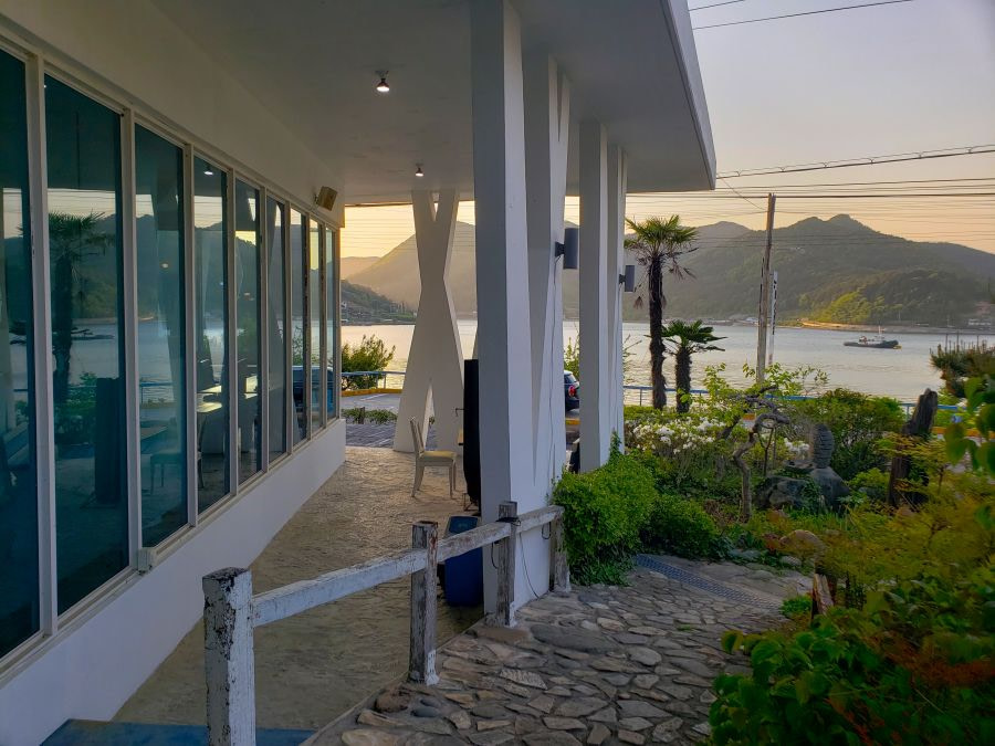 An outdoor garden with a sunset sea and mountain view at & White Café in Goseong, Gyeongnam, Korea