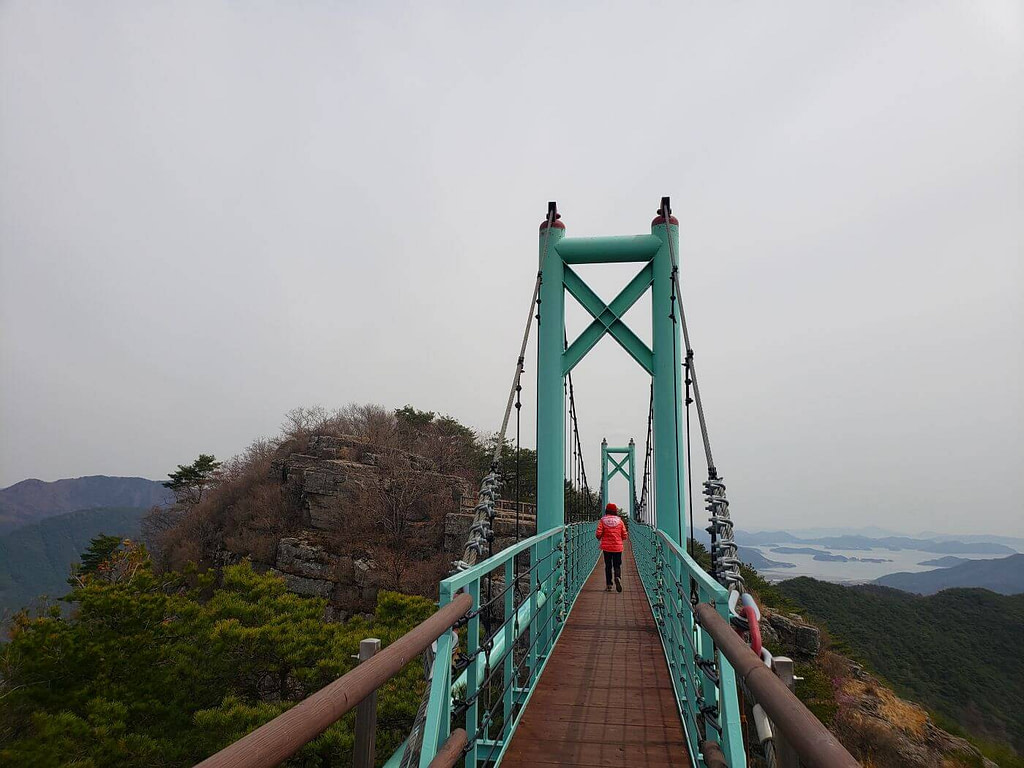 Person walking across suspension bridge to Jeokseoksan Mountain in Goseong